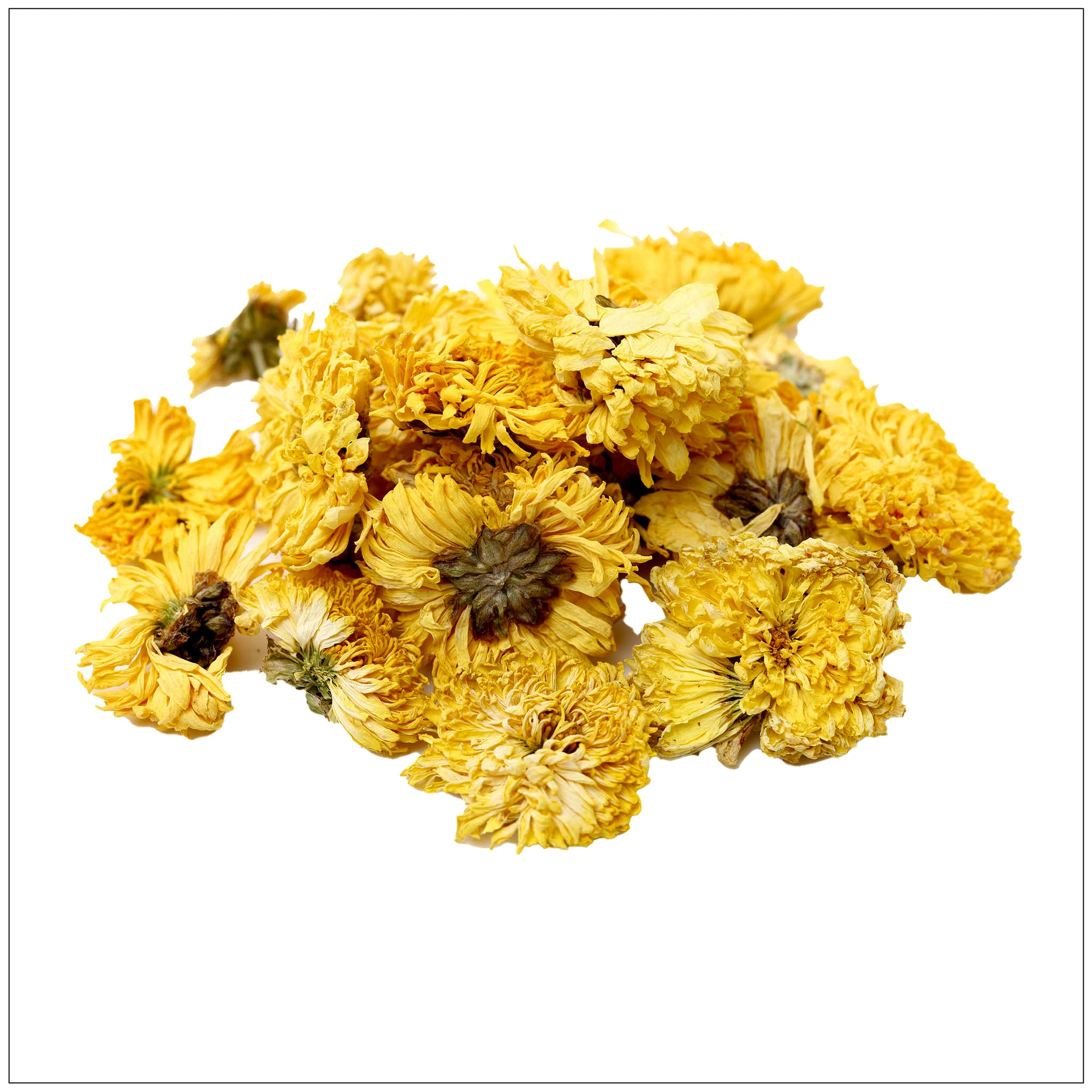 A glass cup of golden chrysanthemum tea on a wooden table with dried flower petals scattered nearby.