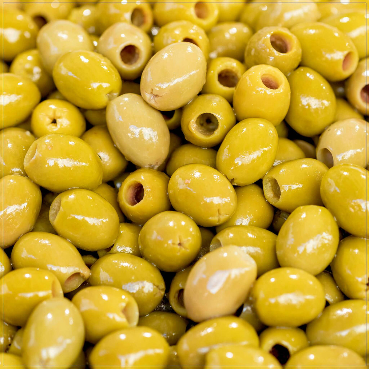 Pitted green olives in a glass jar, USDA-certified premium quality, perfect for salads and snacks.