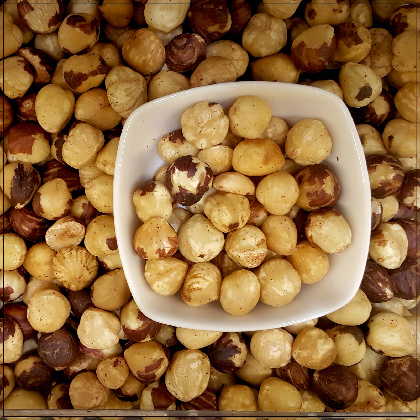 A close-up of roasted unsalted hazelnuts, golden-brown with a smooth texture.