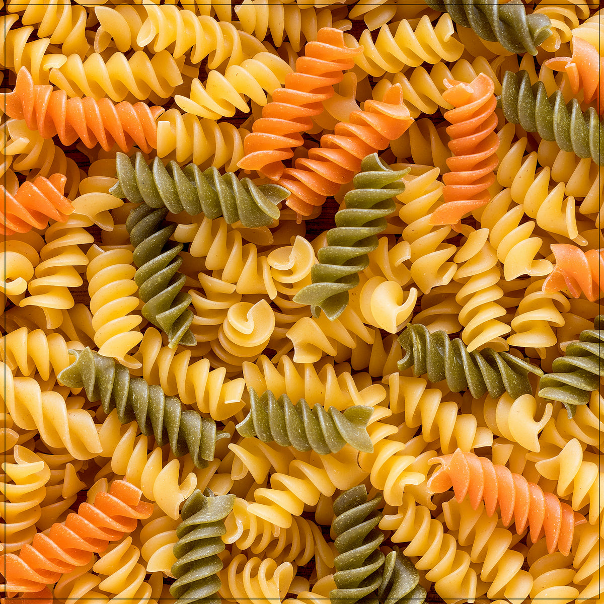 Toasted tri-color pasta with vibrant red, green, and white spirals for a colorful, crunchy side or snack.
