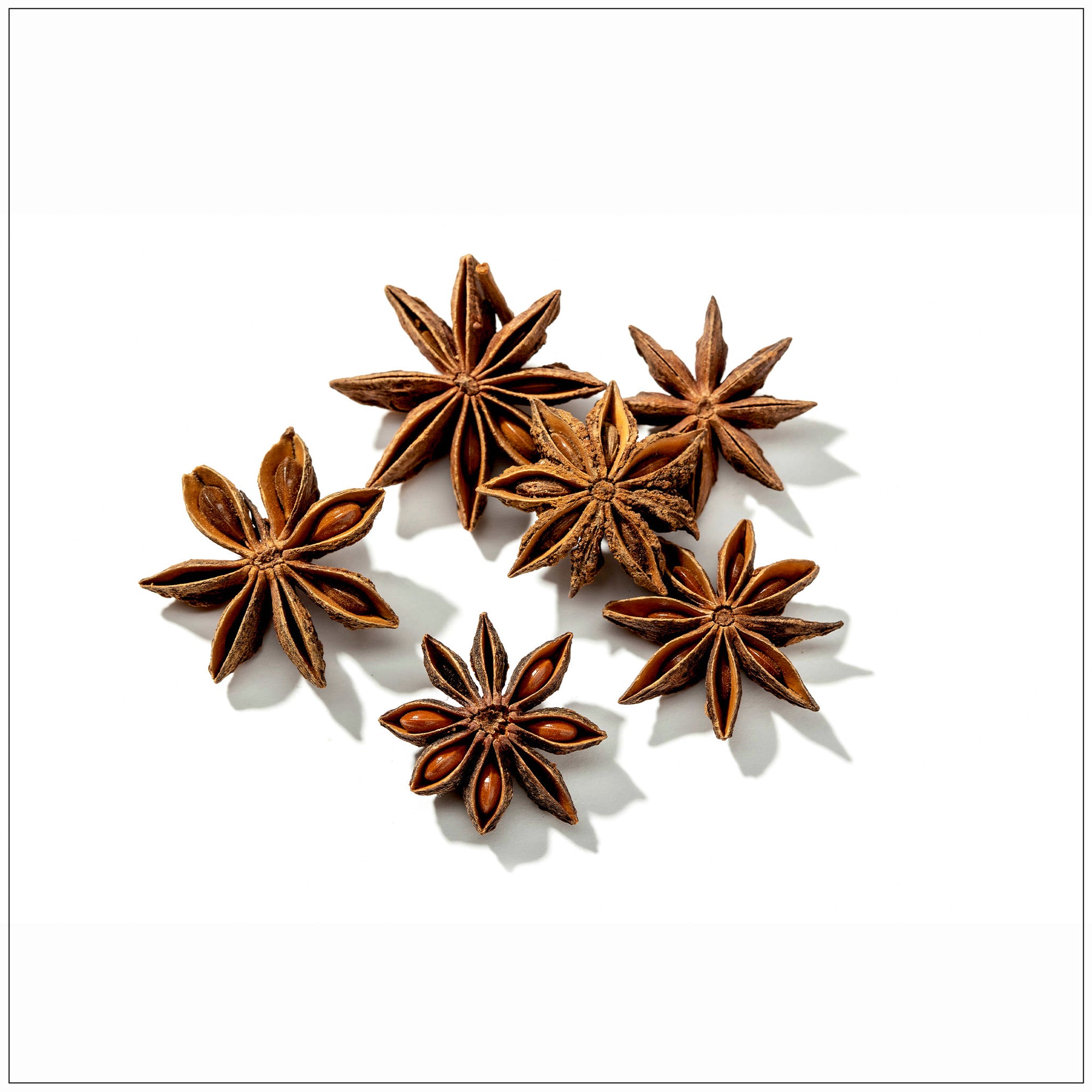 Whole Star Anise pods displayed on a wooden surface, showing their vibrant star-like shape and rich brown color, ideal for cooking, baking, and teas.