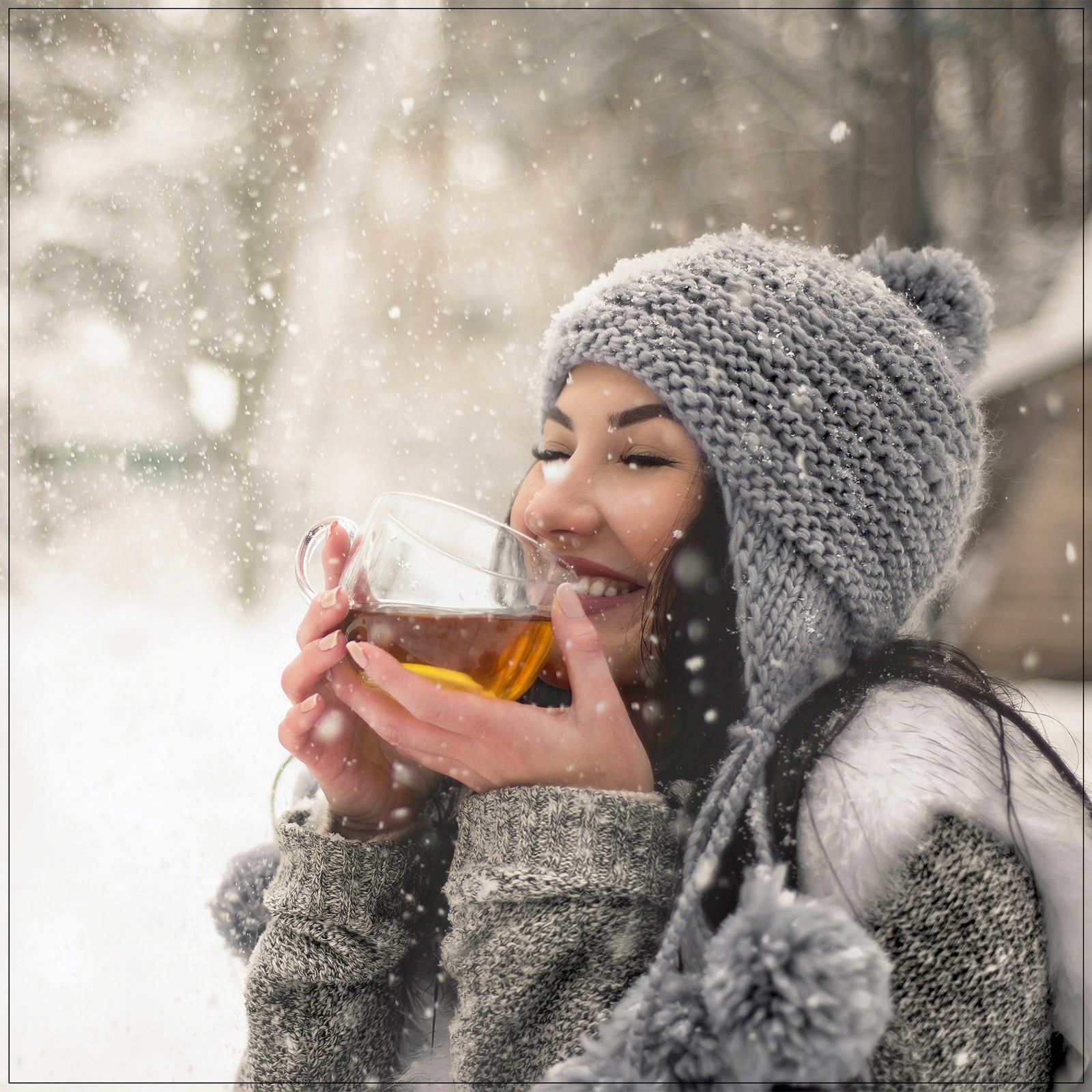 Steaming cup of winter tea with cinnamon and orange slices on a cozy wooden table.